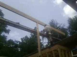 Carpenter setting a ridge beam over a new addition frame — Ice Dam Removal by Roofing Brothers in Pueblo