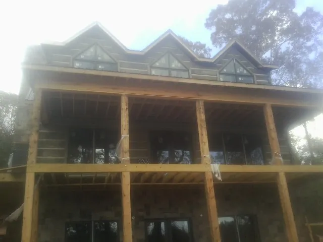 Dormers and porch framing on a large log home under construction — Roof Coating work by our crew in Pueblo