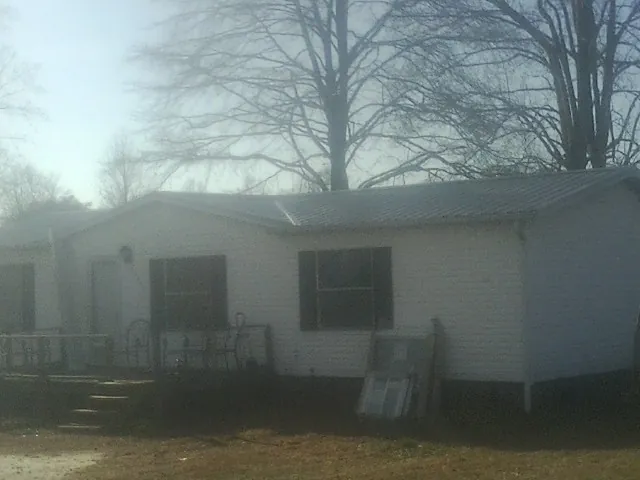 New metal roof on a white painted brick home on a foggy morning in Pueblo