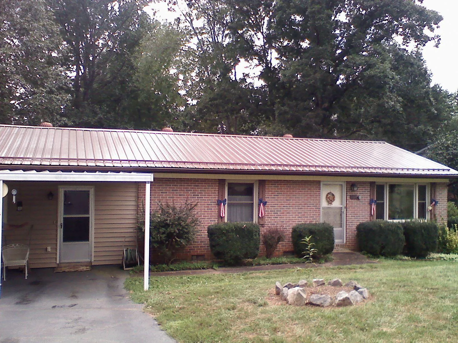 Bronze metal roof and carport on a brick ranch home — Roof Repair work by our crew in Pueblo